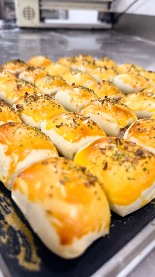 Mini assados dourados com orégano e alho, recém-saídos do forno na assadeira