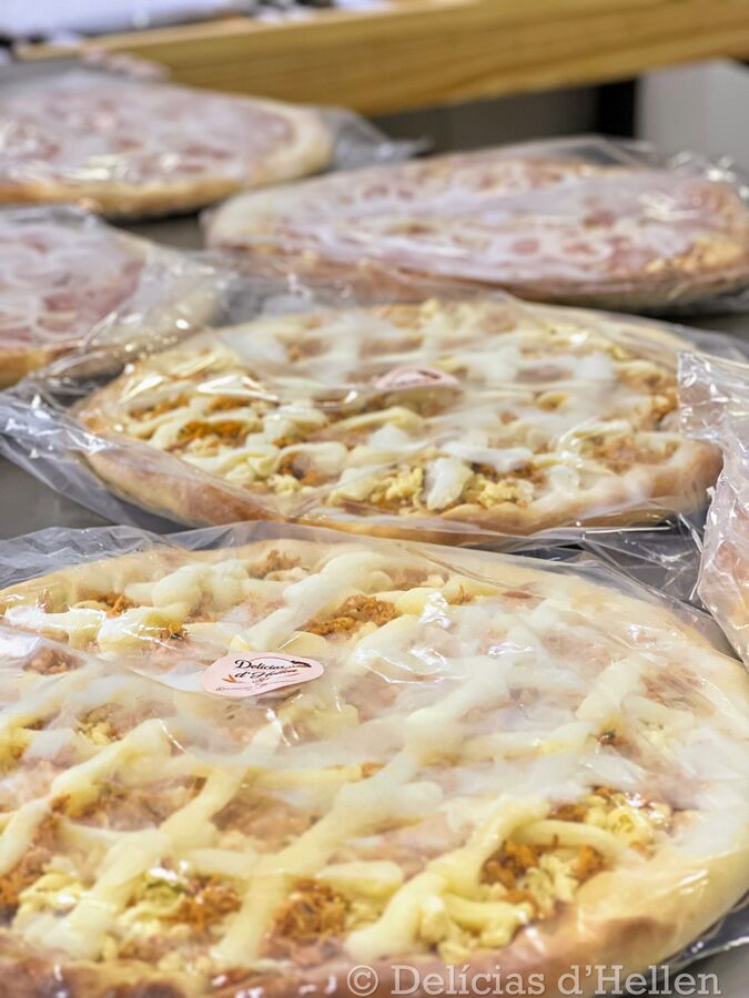 Pizzas embaladas e seladas com o selo Delícias d'Hellen, prontas para venda